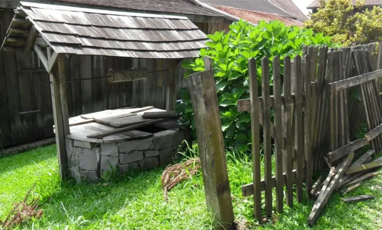 Kamenná studňa s dřevěnou střechou a plotem