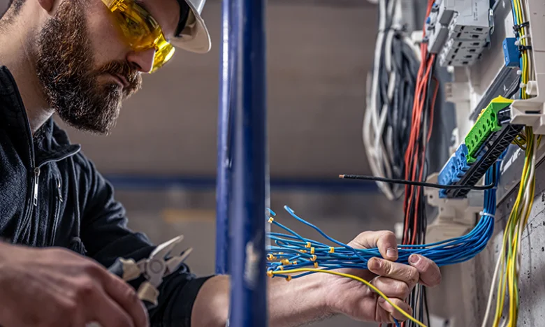 Elektrikář pracuje s kabely v elektroinstalaci.