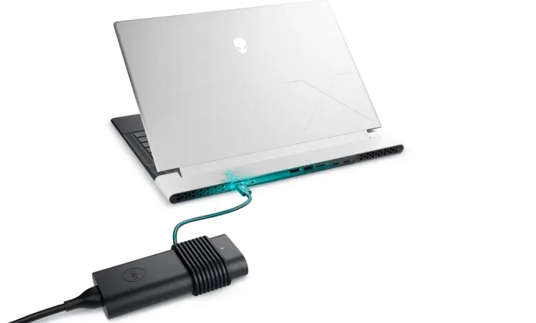 Bílý notebook nabíjen přes USB-C kabel s adaptérem značky Dell.