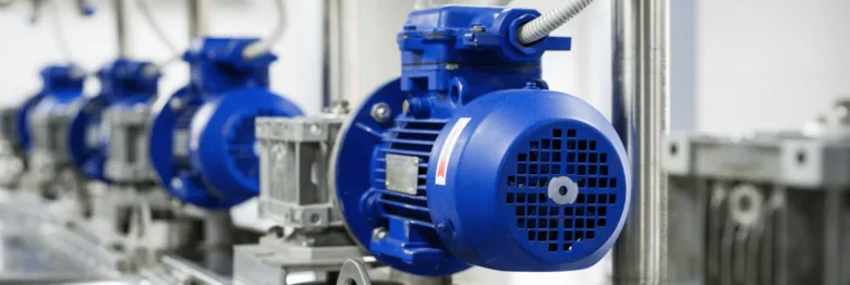 Řada modrých průmyslových elektromotorů v továrně.