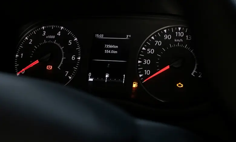 Rozsvícená kontrolka motoru a nízká hladina paliva na přístrojové desce.