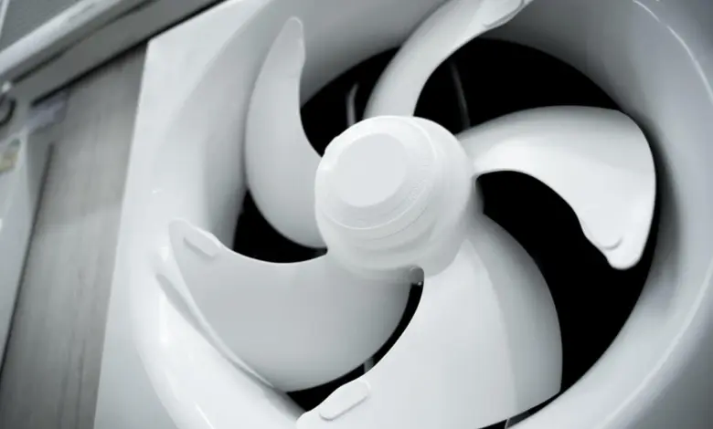 Bílý ventilátor pro větrání koupelny s viditelnými lopatkami.