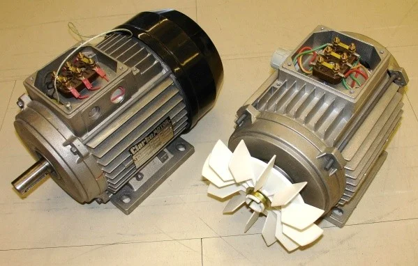 Dva rozložené jednofázové elektromotory s viditelnými cívkami a ventilátorem.