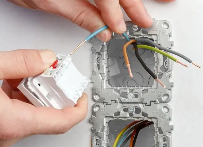 Ruční instalace elektrického spínače s připojením vodičů.