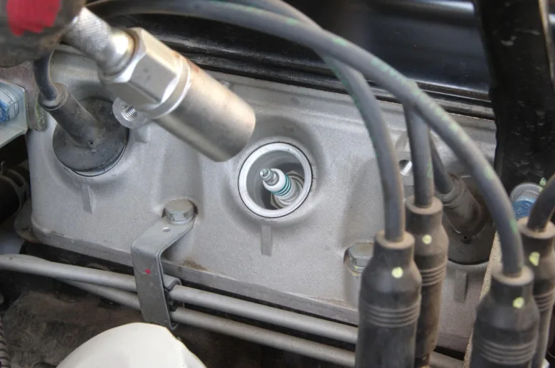 Zapalovací svíčka v motoru s nástrojem pro utahování momentu.