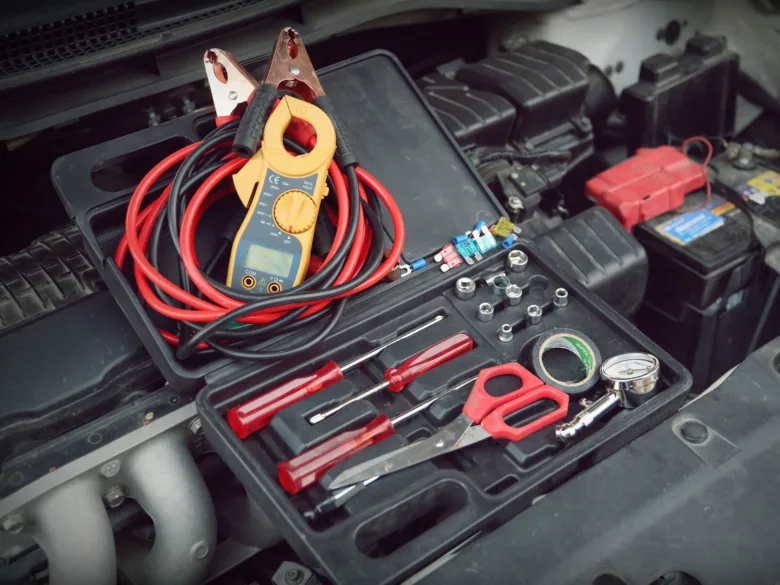 Nástroje pro měření kapacity automobilové baterie v motorovém prostoru.