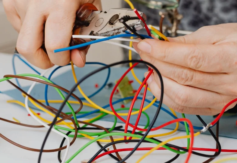 Ruční práce s elektrickými vodiči při instalaci nebo opravě rozvodu.