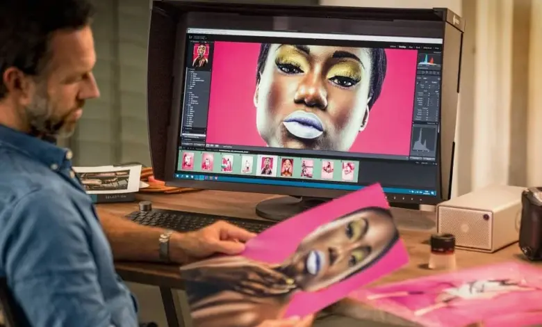 Muž upravuje fotografii na monitoru v profesionálním studiu.