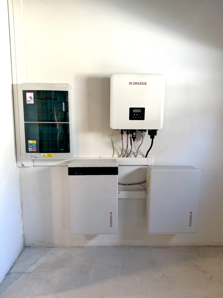 Združená fotovoltaická stanice s inverzory a bateriemi na zdi.