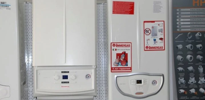 Bílý plynový kotel značky Immergas s nálepkami na boční straně.