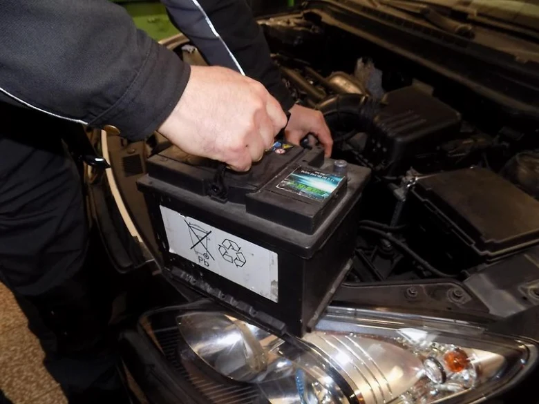 Mechanik odpojil kabely od automobilové baterie pod kapotou.