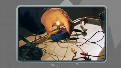 Ruka převinuje cívku elektromotoru s viditelnými jiskrami.