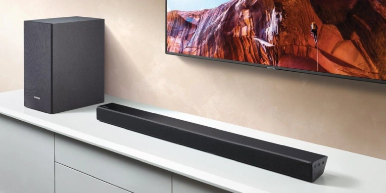 Černá soundbar s bezdrátovým subwooferem pod televizní obrazovkou.