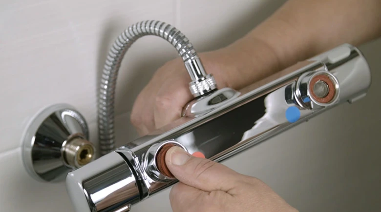 Ručník odšrouvává část termostatické baterie pro opravu.