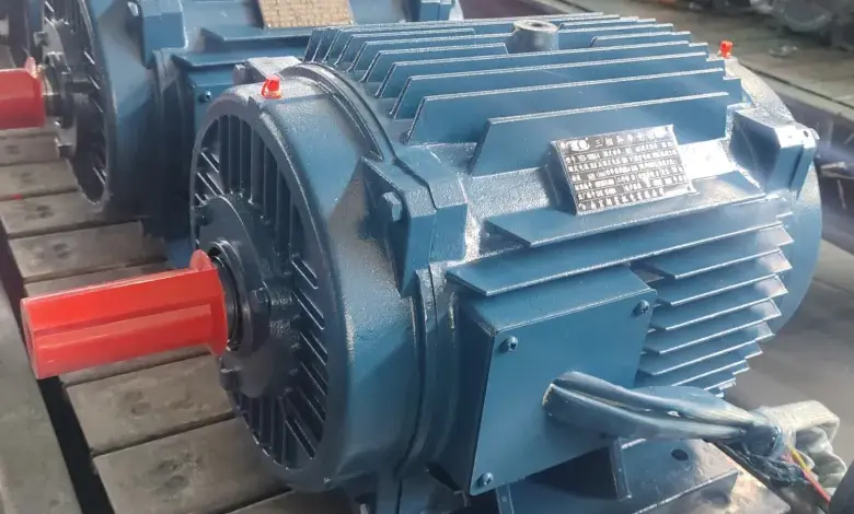Modré průmyslové elektromotory na dřevěných paletách v továrně.