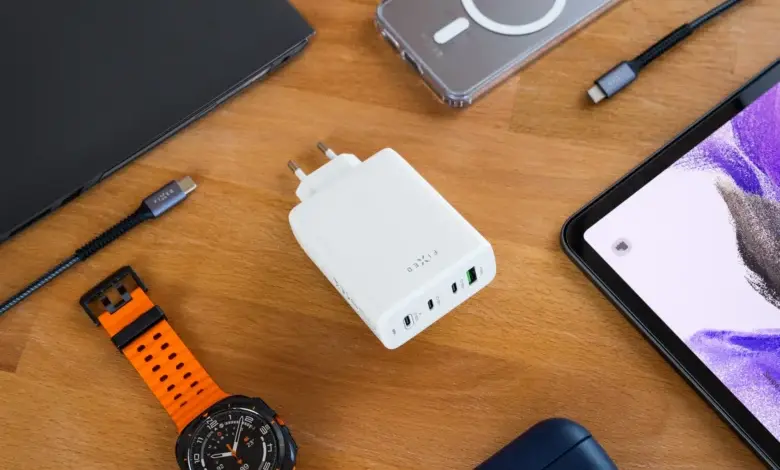 Nabíjecí sada s notebookem přes USB-C kabely na dřevěném stole.