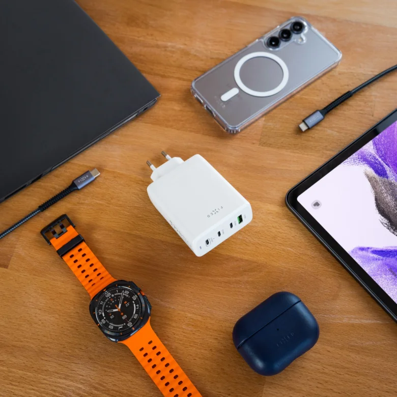 Nabíjecí sada s notebookem přes USB-C kabely na dřevěném stole.