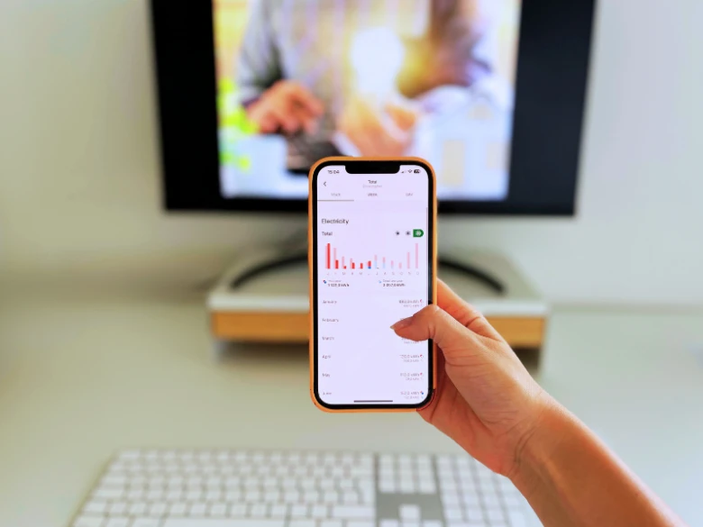Mobilní telefon s aplikací pro sledování spotřeby elektřiny.