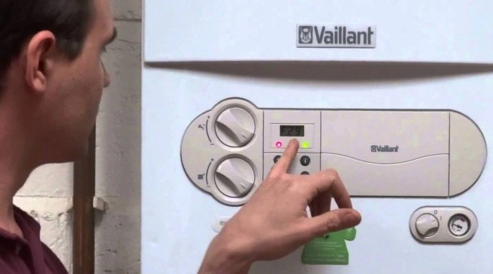 Muž nastavuje ovládací panel kotle značky Vaillant.
