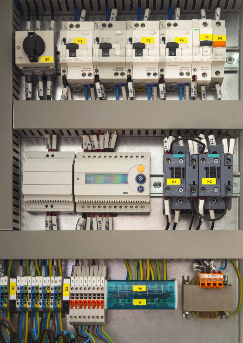 Vnitřek rozvaděče s uzemňovacím lištou PE v české elektroinstalaci.