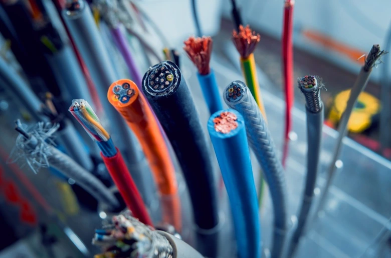 Různé odříznuté elektrické kabely s viditelnými měděnými vodiči.