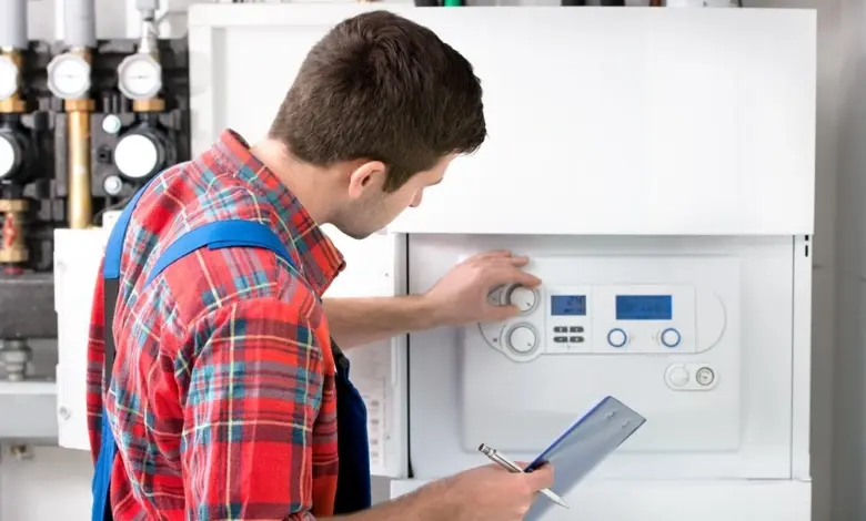 Technician inspecting boiler control panel