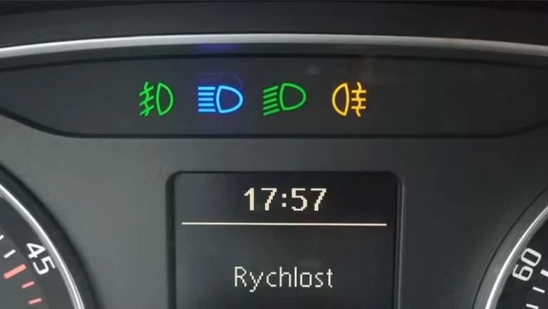 Přístrojová deska automobilu s rozsvícenými indikátory denního svícení a mlhovky.