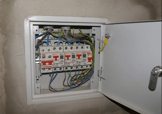 Otevřená skříň s pojistkami a zapojenými vodiči v elektrické rozvadže