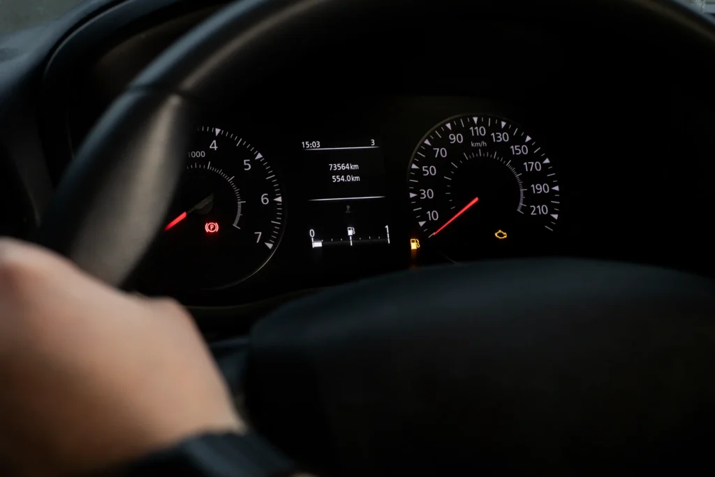 Rozsvícená kontrolka motoru na přístrojové desce vozu.