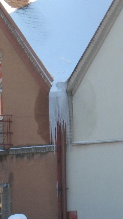 Ledovce na okapovém žlabu ukazují problém s odvodem dešťové vody.