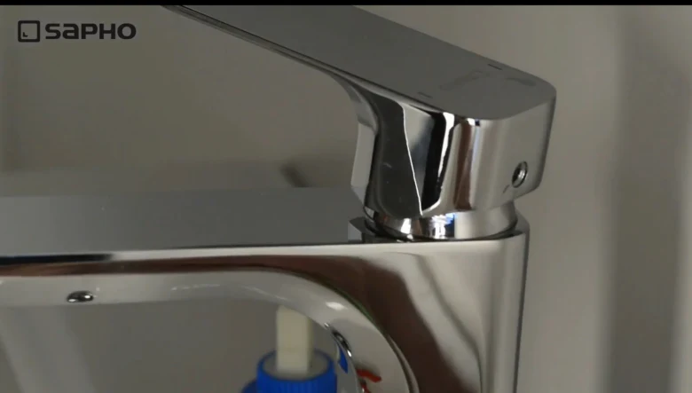 Detail chromové baterie v koupelně pro opravu nebo výměnu.
