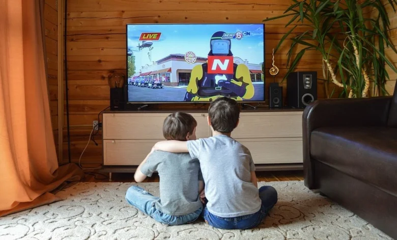 Dva chlapci sedí před televizorem v obývacím pokoji.