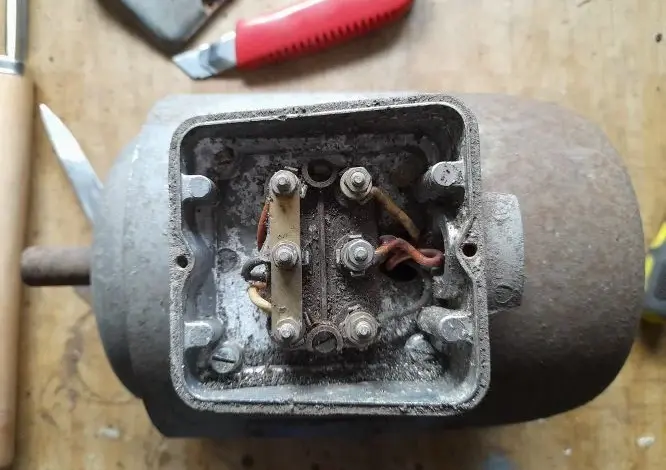 Otevřený terminál elektromotoru s viditelnými vodiči pro přepojení.