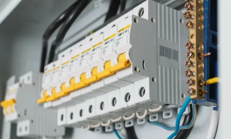 Bílé jističe s žlutými spínači v rozvaděči elektrické instalace.