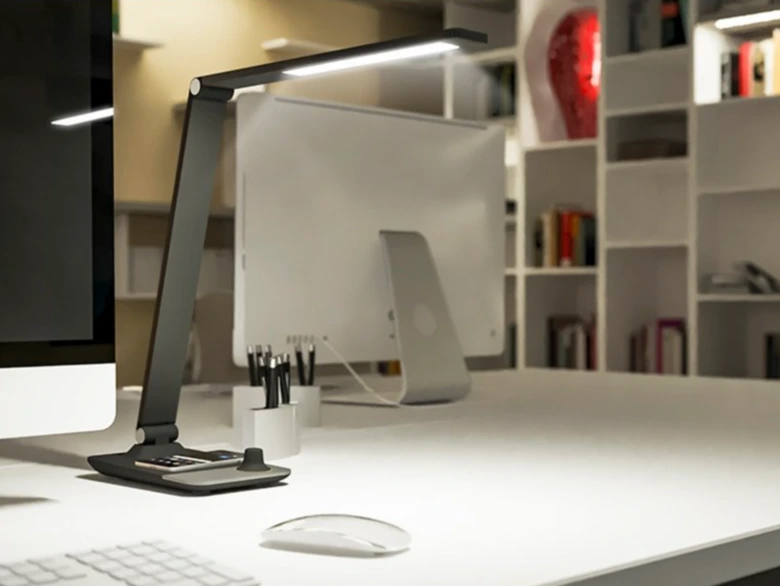 Moderní stolní lampa na bílém pracovním stole v kanceláři.