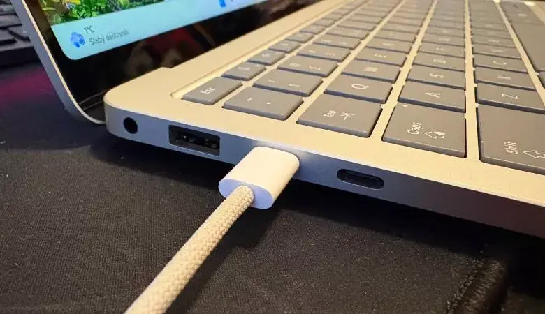 Bílý kabel je připojen k notebooku pro nabíjení doma.