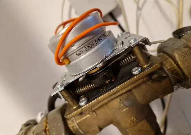 Blízký záběr na třístupňový ventil s elektromagnetickou cívkou a odšroubovaným krytem.