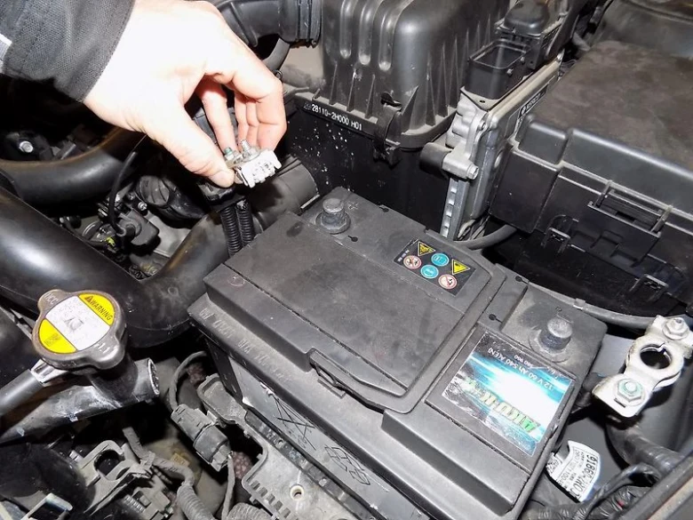 Ruční odpojení konektoru od autobaterie v motorovém prostoru.