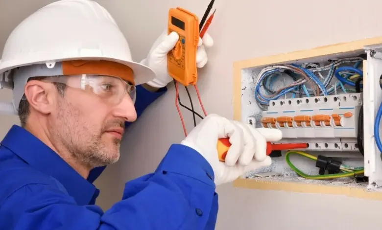 Elektrikář měří napětí v rozvaděči s multimetrem.