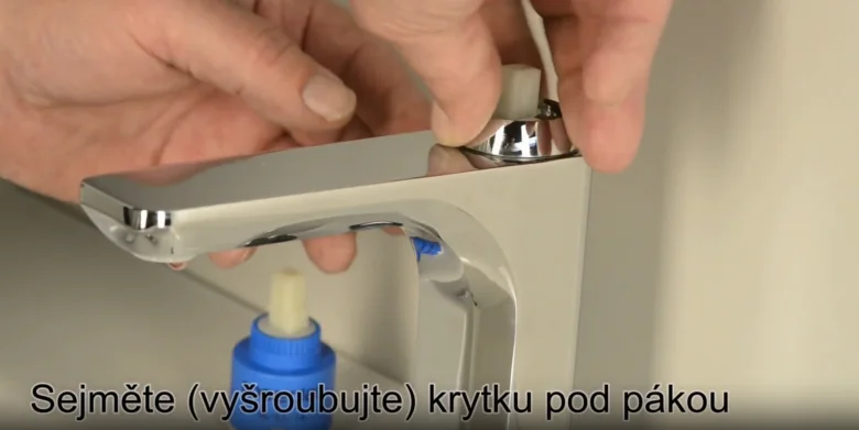 Ruční demontáž krytky na kohoutku v koupelně.