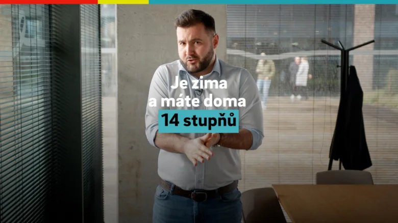 Muž v interiéru s českým textem o zimních teplotách ve bytě.