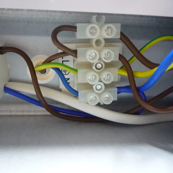Hnědý a modrý vodič připojené na elektrický spojovací blok.