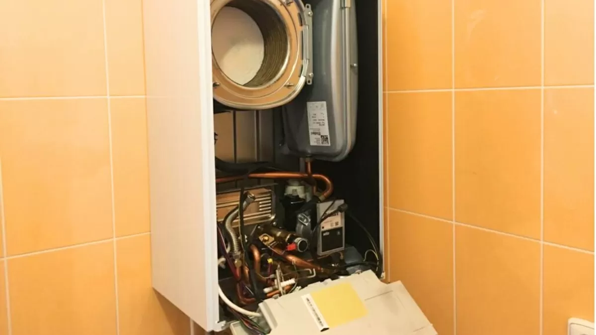 Vnitřní součástky plynového kotle s odhalenými hadicemi a elektronikou.