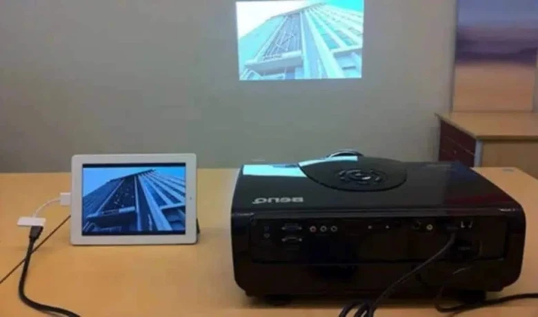 Projektor připojený k tabletu pro streamování obsahu na obrazovku.