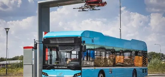 Modrá elektrická autobus u stanice pro bezdrátové nabíjení baterií.