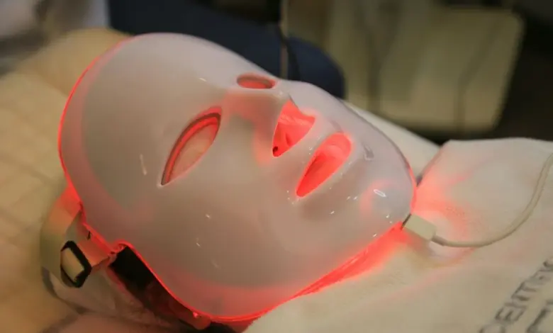 Červená světelná terapie na obličeji pomocí LED masky.
