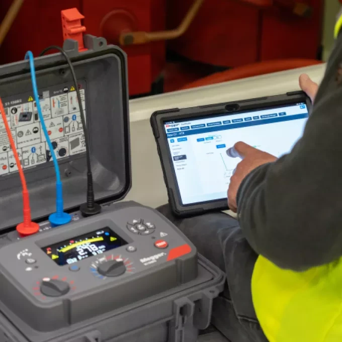 Technik testuje izolační odpor pomocí digitálního měřicího přístroje s tabletem.