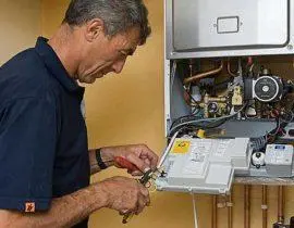 Technik opravuje vnitřní součástky plynového kotle Ferroli.