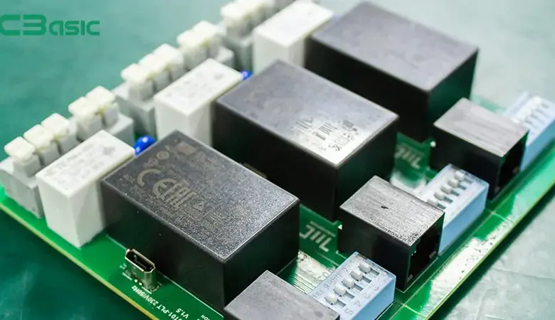 Zelená deska s mnoha černými elektromagnetickými relémi.