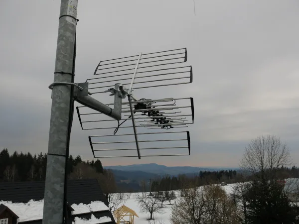 Televizní anténa na stoce v zimním krajině.